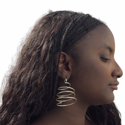 Woman wearing a gold hoop earring with a plain background